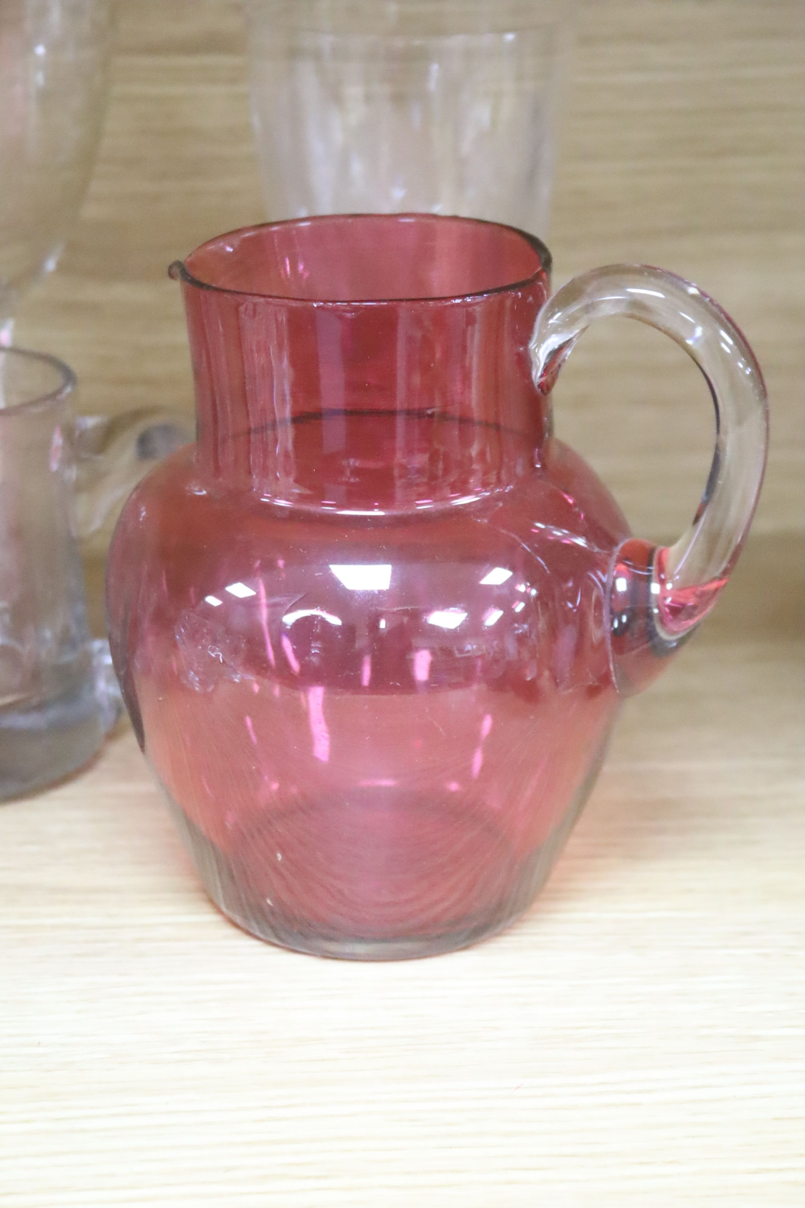 A Victorian cranberry glass jug and mixed glass